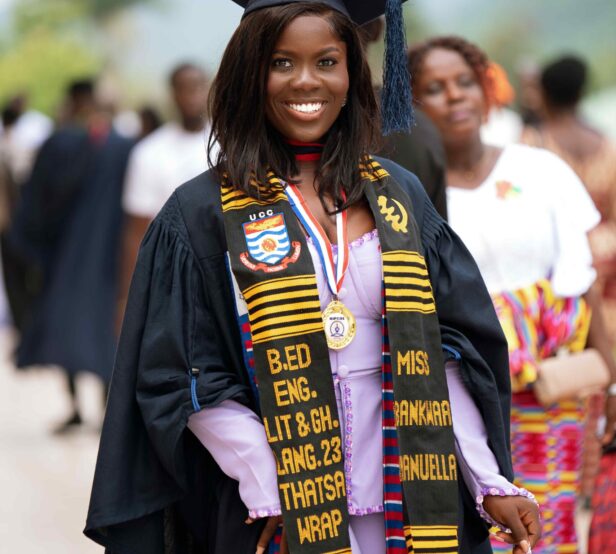 Female graduate smiling in cap and gown with a Kente Graduation Stole