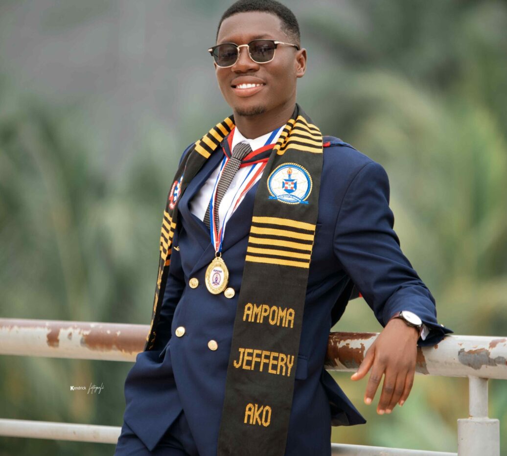 Male graduate in suit wearing a black and gold Kente Graduation Stole