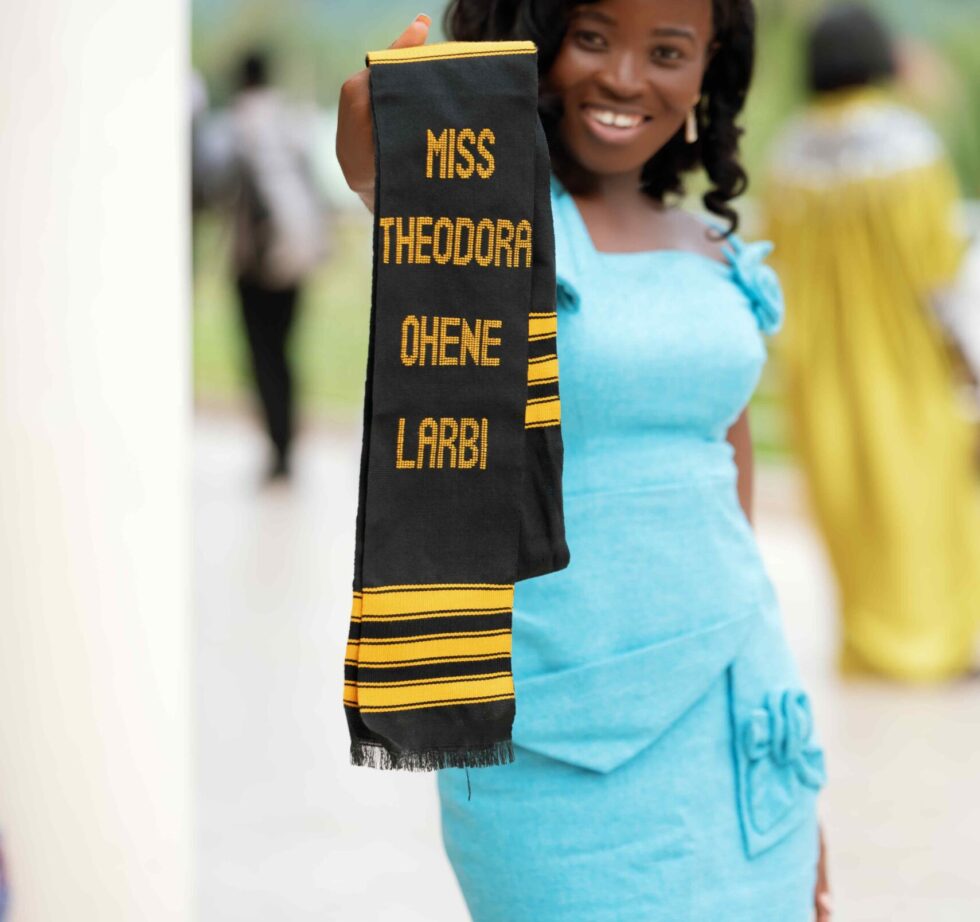 Graduate presenting a personalized Kente Graduation Stole and sash