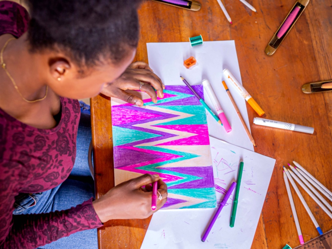 Designer sketching a storytelling Kente pattern for bespoke weaving